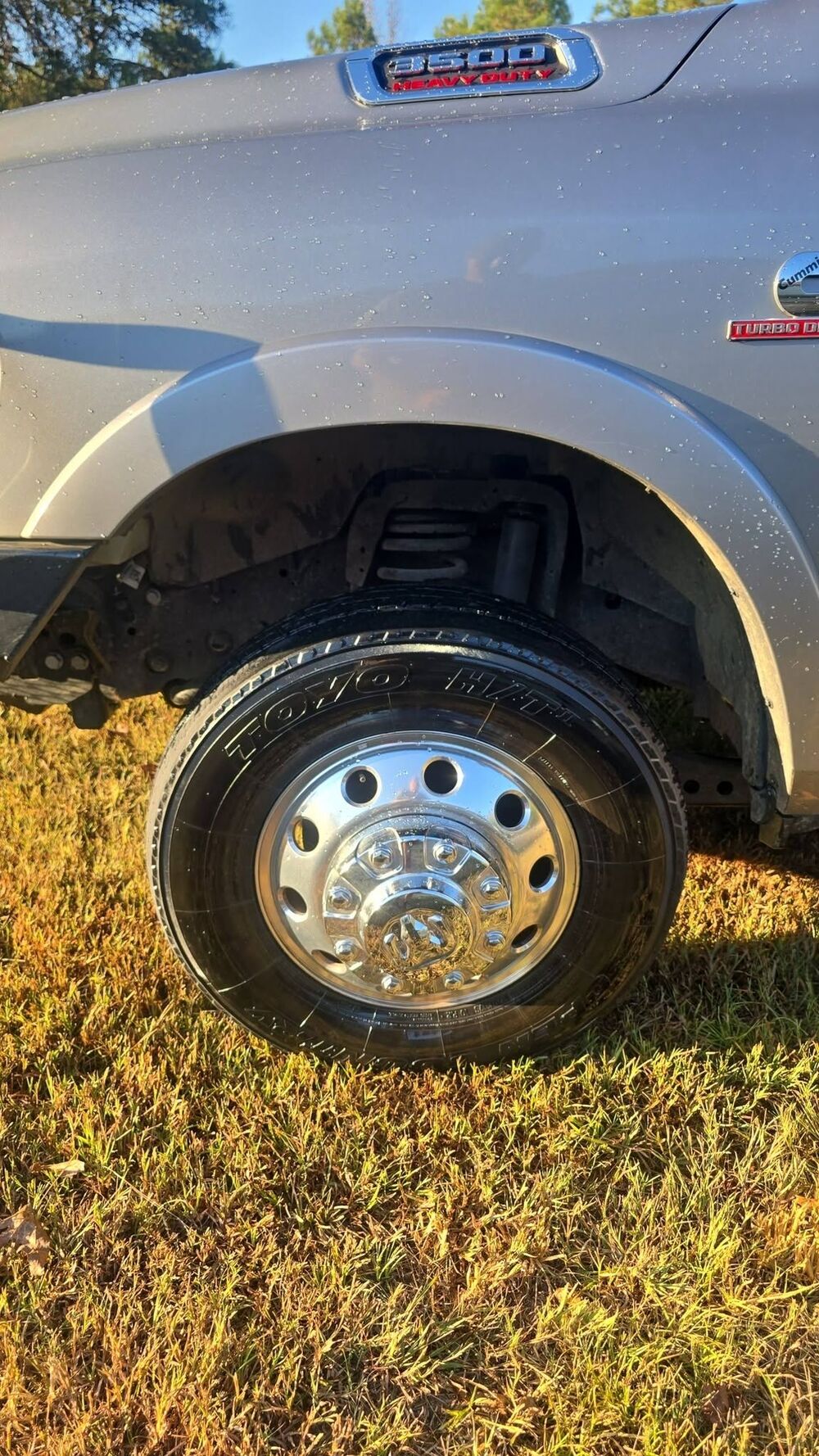 Polished dually wheel and dressed tire on a grey Ram 3500