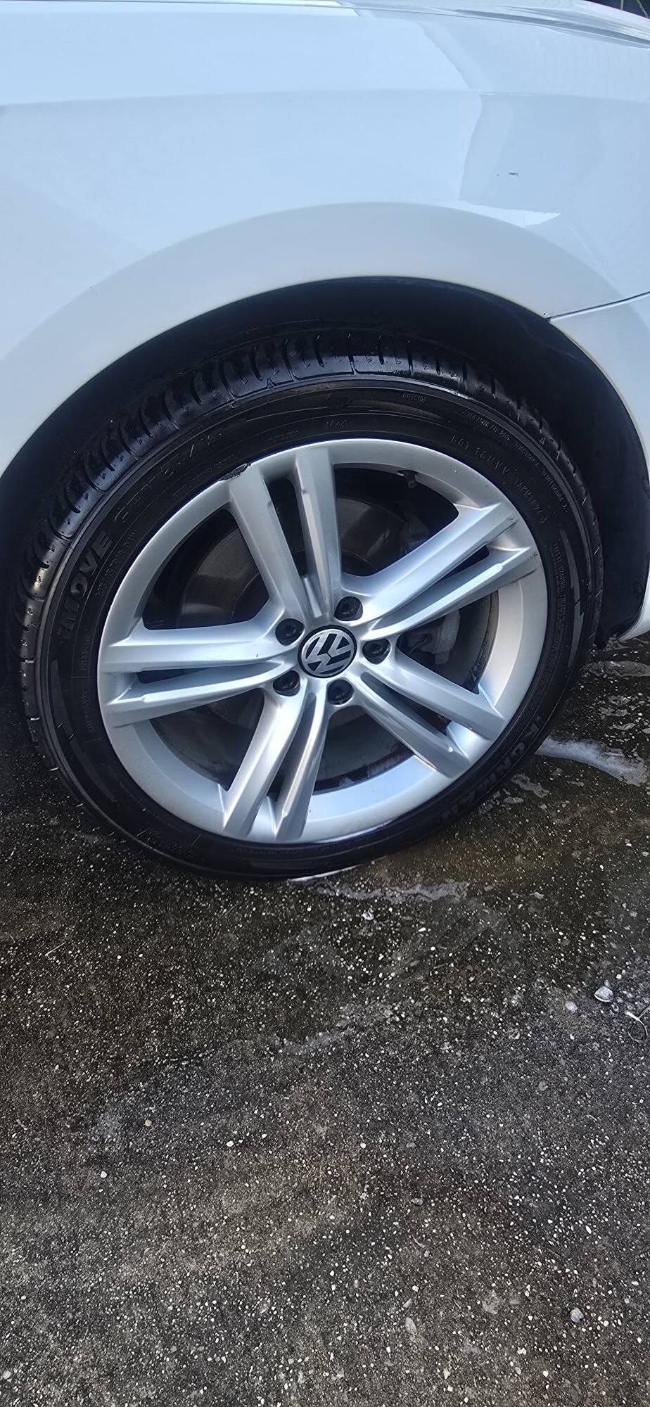 Clean alloy wheel and shined tire on a white Volkswagen